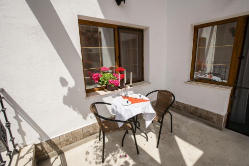 a table with chairs and flowers on a balcony at Pensiunea Vila Europa in Deva