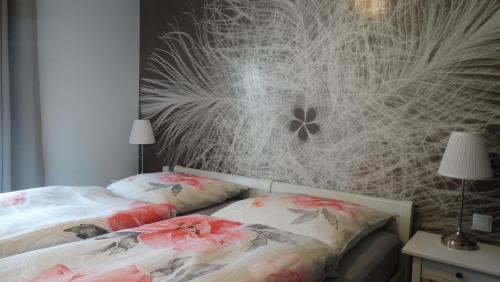 1 Schlafzimmer mit 2 Betten mit Blumen an der Wand in der Unterkunft Buntspecht in Braunlage