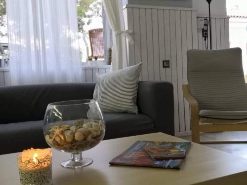 a living room with a table with a candle and a glass vase at Hotel Rania in Loutra Edipsou
