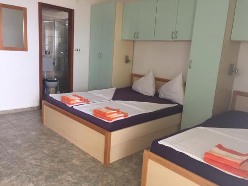 two beds in a room with towels on them at Apartmani Atila Damir in Omiš