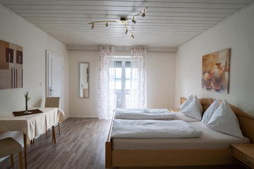 ミルシュタットにあるPension Pleiknerのベッドルーム1室(ベッド2台、テーブル、窓付)