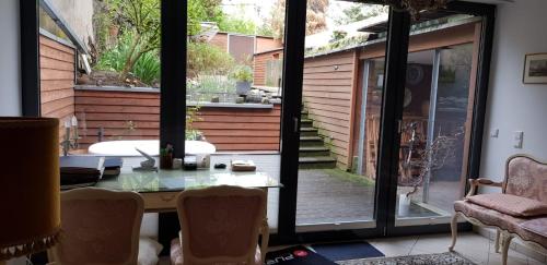 Zimmer mit einem Tisch und einer Glasschiebetür in der Unterkunft B8 - just a private accommodation in Düsseldorf