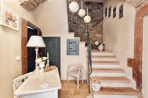 a staircase in a home with a stone wall at Domo 'e sa rosa in Bosa