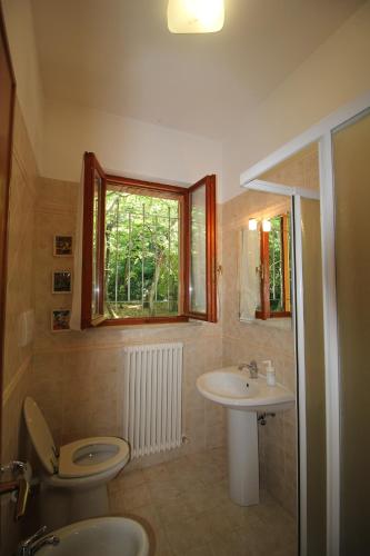 a bathroom with a sink and a toilet and a window at Villa Mombaroccio le colline di Pesaro tra mare e natura in Mombaroccio
