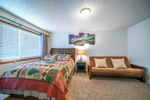 um quarto com uma cama, uma cadeira e uma janela em Polar Bear Den em Anchorage