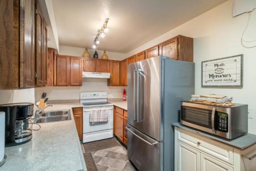 a kitchen with wooden cabinets and a stainless steel refrigerator at Polar Bear Den in Anchorage