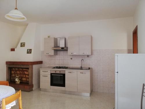 a kitchen with a stove and a refrigerator at Casa vacanza in Fluminimaggiore