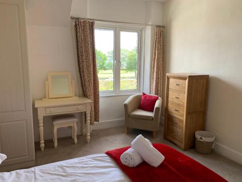 um quarto com uma cama, uma cadeira e uma janela em Postmans Rest, second floor apartment, Lynmouth with private parking em Lynmouth