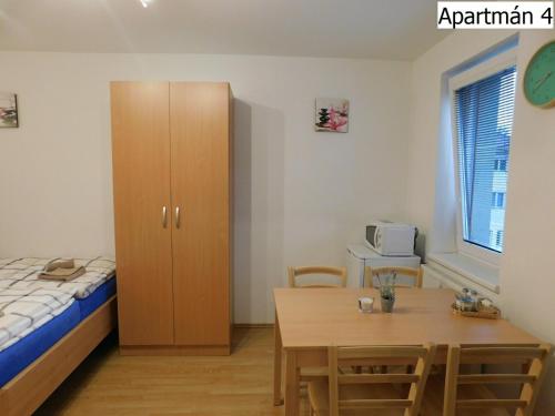 a bedroom with a bed and a table and a cabinet at Apartmány Horní Planá in Horní Planá