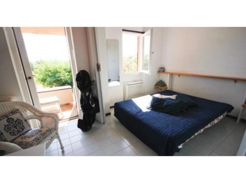 una camera con un letto e una sedia e una finestra di Le Miniere Apartments a Monte Argentario