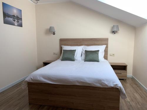 a bedroom with a large white bed with two pillows at Willa Kormoran in Augustów
