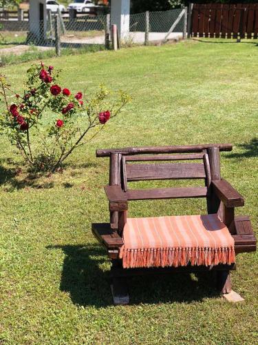 a wooden bench sitting in a field of grass at Etno Domaćinstvo Stanković in Gornji Milanovac