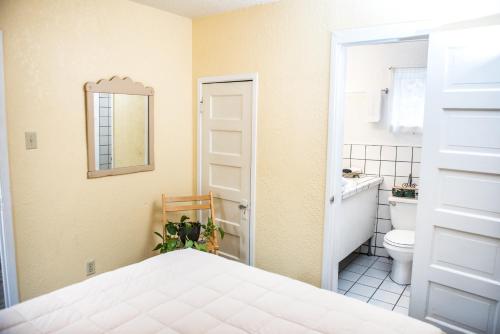 a bathroom with a bed and a toilet and a mirror at Jonquil Motel in Bisbee