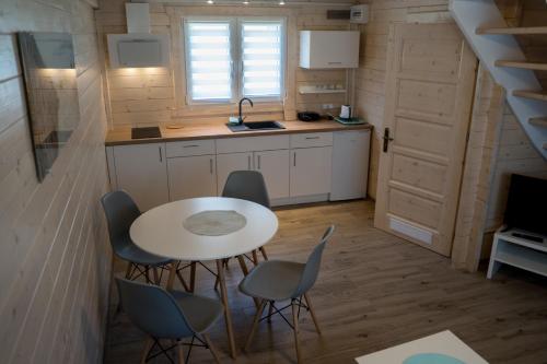 a kitchen with a table and chairs in a tiny house at Te Domki in Łukęcin