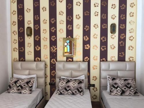 a bedroom with two beds and a wall with flowers at Riad Najiba in Rabat
