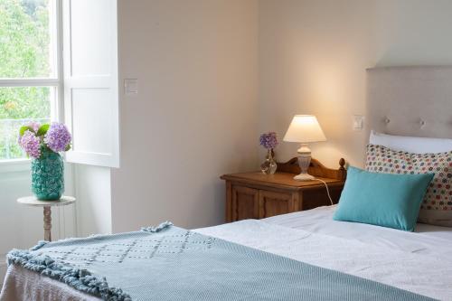 a bedroom with a bed and a vase of flowers on a table at Posada Seis Leguas in Ríocorvo