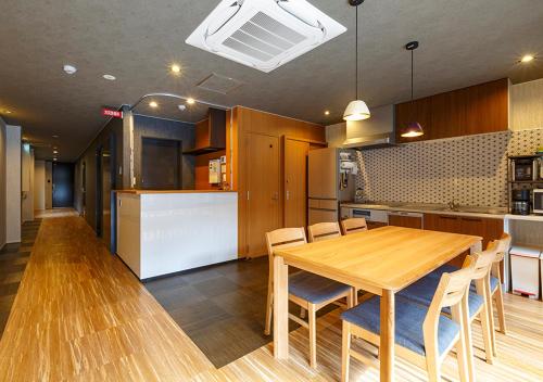 a kitchen and dining room with a wooden table and chairs at Guest House Goettingen in Kyoto