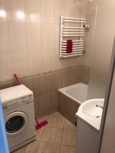 a bathroom with a washing machine and a sink at Pułaskiego 13/17 m.6 Apartament in Gdańsk
