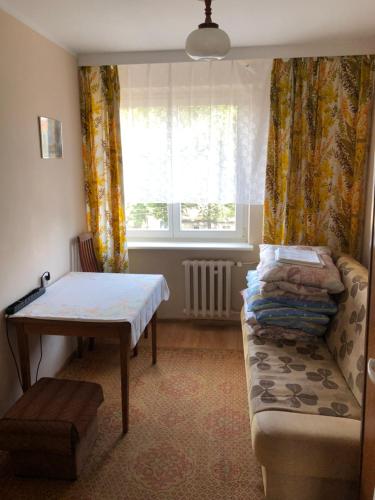 a room with a couch and a table and a window at Pułaskiego 13/17 m.6 Apartament in Gdańsk