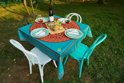 a blue table with chairs and a bottle of wine at Ethno Sazano Hotel in Sazano