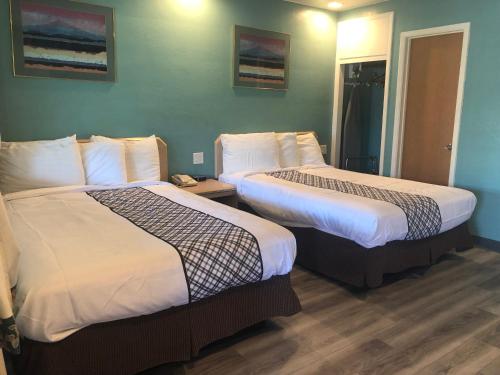 a hotel room with two beds in a room at Bestway Inn in Grants Pass
