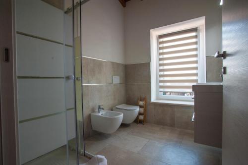 a bathroom with a toilet and a glass shower door at Gate To Verona in Verona