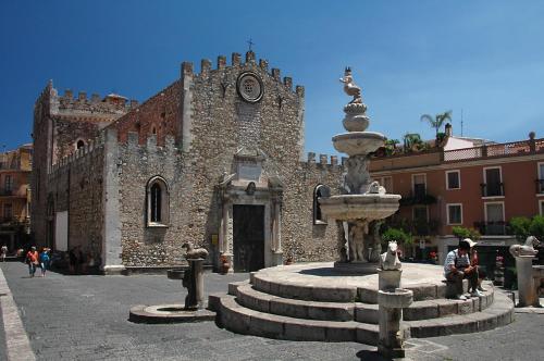 a stone building with a fountain in front of it at Casa Romeo in Taormina