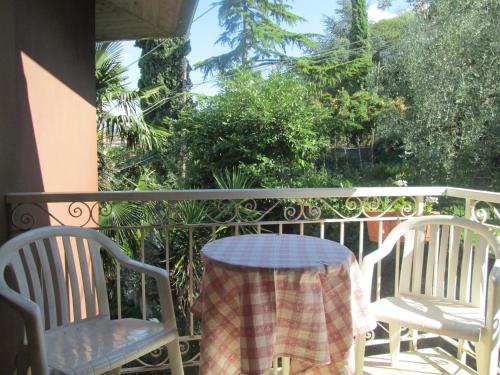 a porch with two chairs and a table with a blanket on it at B&B Casa Sartori in Malcesine