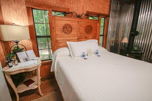 ein Schlafzimmer mit einem Bett und einem Tisch mit einer Lampe in der Unterkunft The Tree House in Tyler