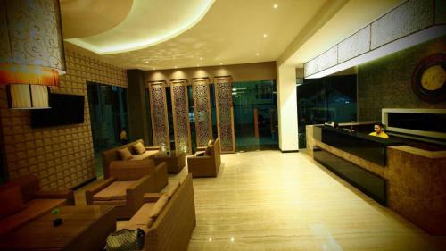 a lobby of a hotel with couches and a person sitting in the lobby at De Boutique Style Hotel in Malang