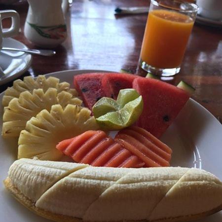 a plate of food with fruits and vegetables on a table at Poseidon Bungalows in Khao Lak