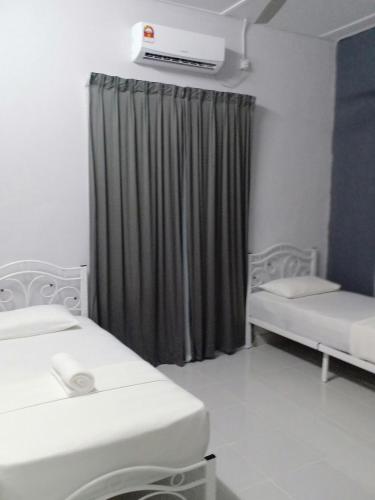 a hospital room with two beds and a curtain at TEBiNG Guest House Taman Negara Malaysia Kuala Tahan in Kuala Tahan