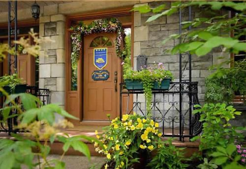 a house with a brown door and some flowers at Accueil Chez Francois in Montréal
