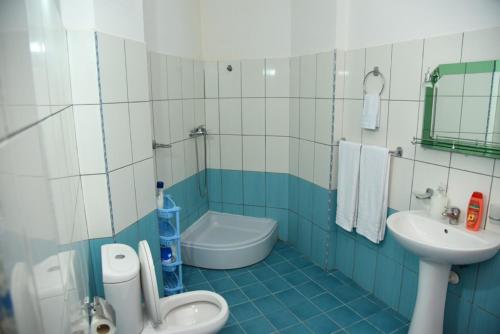 a blue and white bathroom with a toilet and a sink at gzim's apartment in Durrës