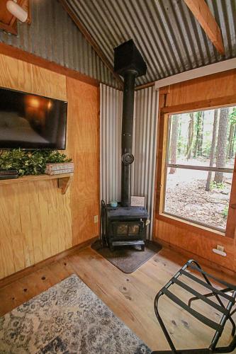 a living room with a wood stove in a cabin at Happy Pine Cone in Tyler