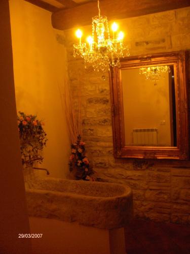 a bathroom with a mirror and a sink and a chandelier at appartamento Colticciola Agriturismo Marche in Cagli