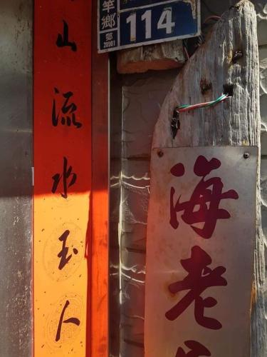 a sign with chinese writing on it next to a wall at Eternal Seaside House in Nangan