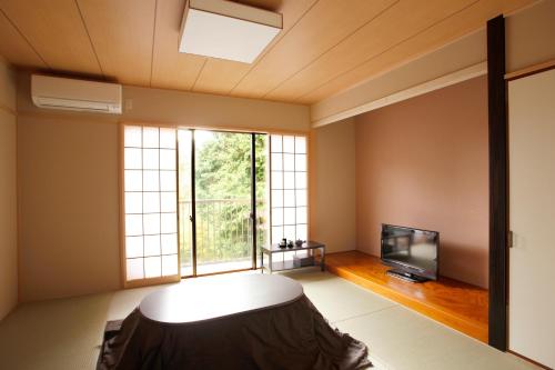 a living room with a large window and a tv at Hakone Fura in Hakone
