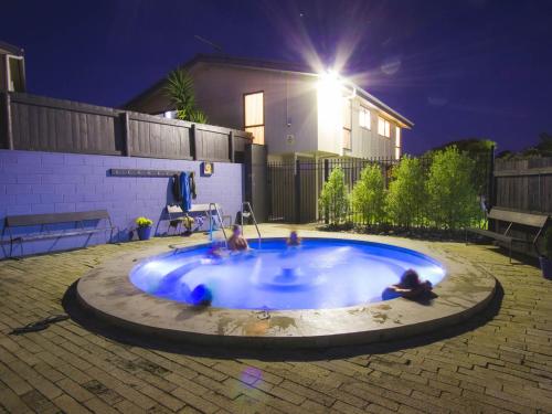 a swimming pool in the middle of a yard at night at Pacific Park Christian Holiday Camp in Papamoa