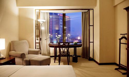 um quarto de hotel com uma cama, uma secretária e uma janela em Rosedale Hotel & Suites Guangzhou - Free Shuttle Bus to Canton Fair em Guangzhou