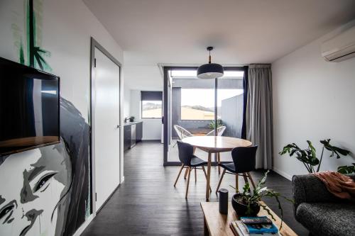 a living room with a table and a dining room at Change Overnight in Launceston