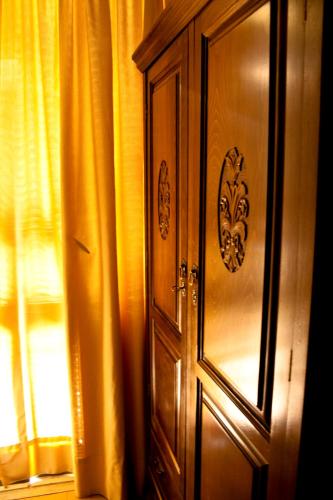 a wooden cabinet next to a window with curtains at Acropolis House in Athens