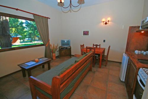 a living room with a couch and tables and a tv at Estancia Del Carmen Mountain Resort in San Carlos de Bariloche