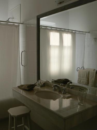 a bathroom with a sink and a large mirror at La Merced Del Alto in Cachí