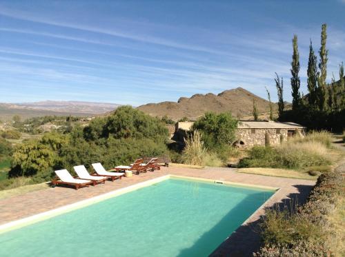 a swimming pool with lounge chairs and a view of the mountains at La Merced Del Alto in Cachí