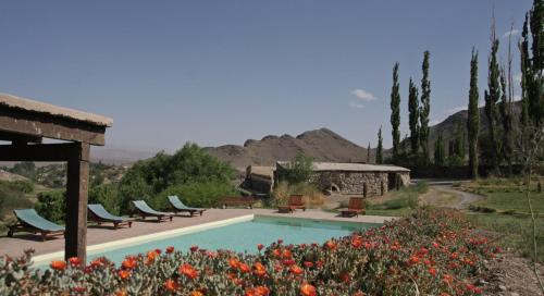 a patio area with a pool and lawn chairs at La Merced Del Alto in Cachí