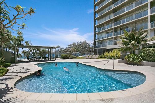 a swimming pool in front of a building at One The Esplanade Apartments on Surfers Paradise in Gold Coast