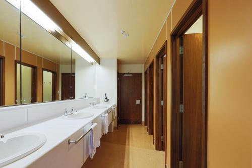 a bathroom with three sinks and a large mirror at Pinewood Lodge and Apartments in Queenstown