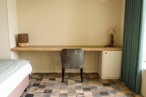 a bedroom with a desk with a chair and a bed at Landhuis Eikenburg in Ypres