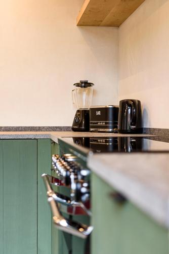 a kitchen with a stove top oven next to a counter at Landhuis Eikenburg in Ypres